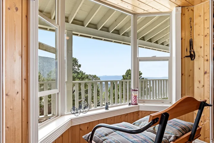 Wood-paneled interior walls and ceiling, with a bay window featuring white trim