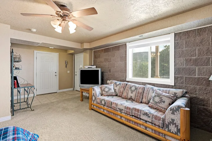 Recessed ceiling with an integrated light fixture, carpeted flooring, and a large window