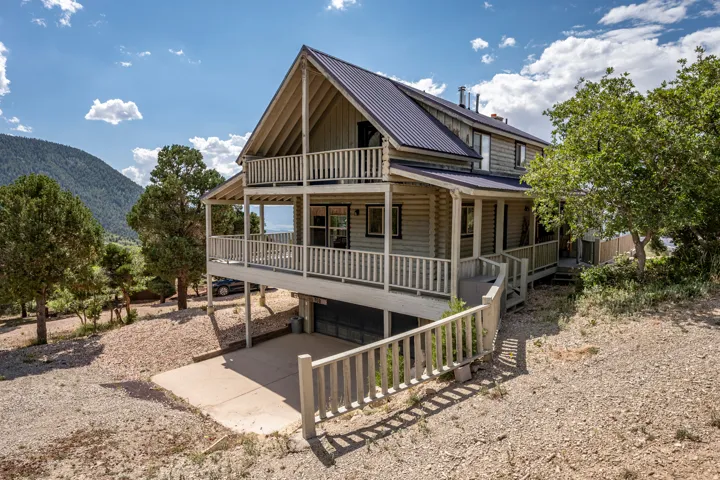 Mountain backdrop with a multi-level structure featuring log-style siding and an angular roofline