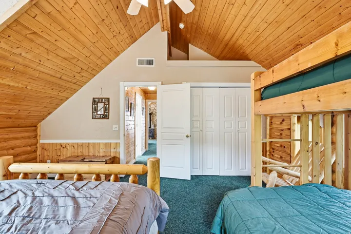 Vaulted wood-finish ceiling, wood-paneled walls, built-in bunk beds, wood-finish flooring