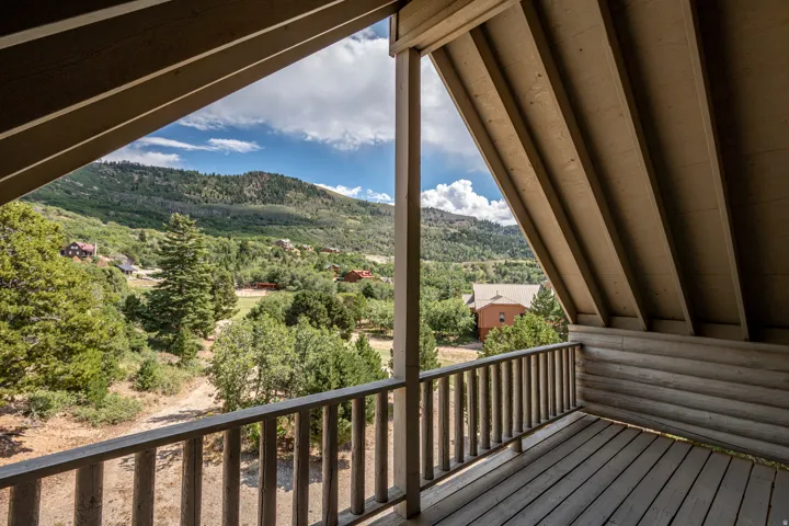 Expansive outdoor deck featuring a wooden railing, a log-style exterior wall, and wood decking