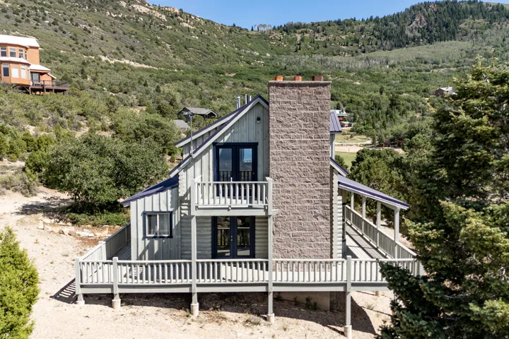 Board and batten exterior with a stone-clad chimney