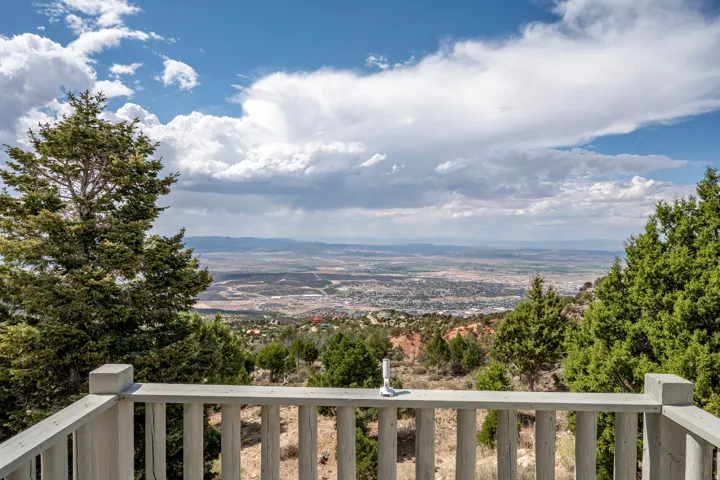 Expansive mountain and valley scenery, highlighted by a wooden railing