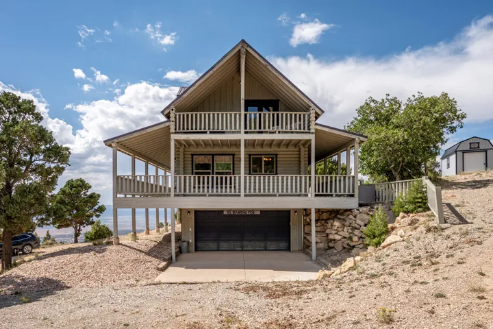 A-frame style exterior with wood siding, dual-level covered balconies, and a ground-level garage