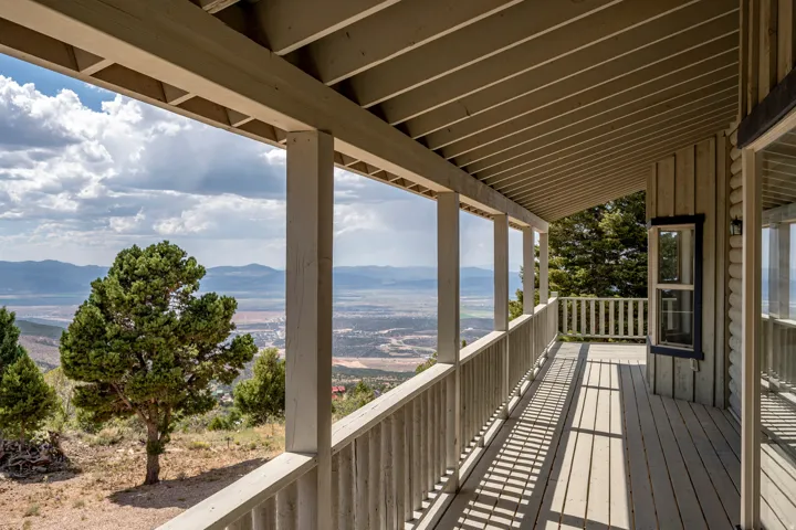 Expansive covered deck featuring wood decking, wood posts, and a wood railing