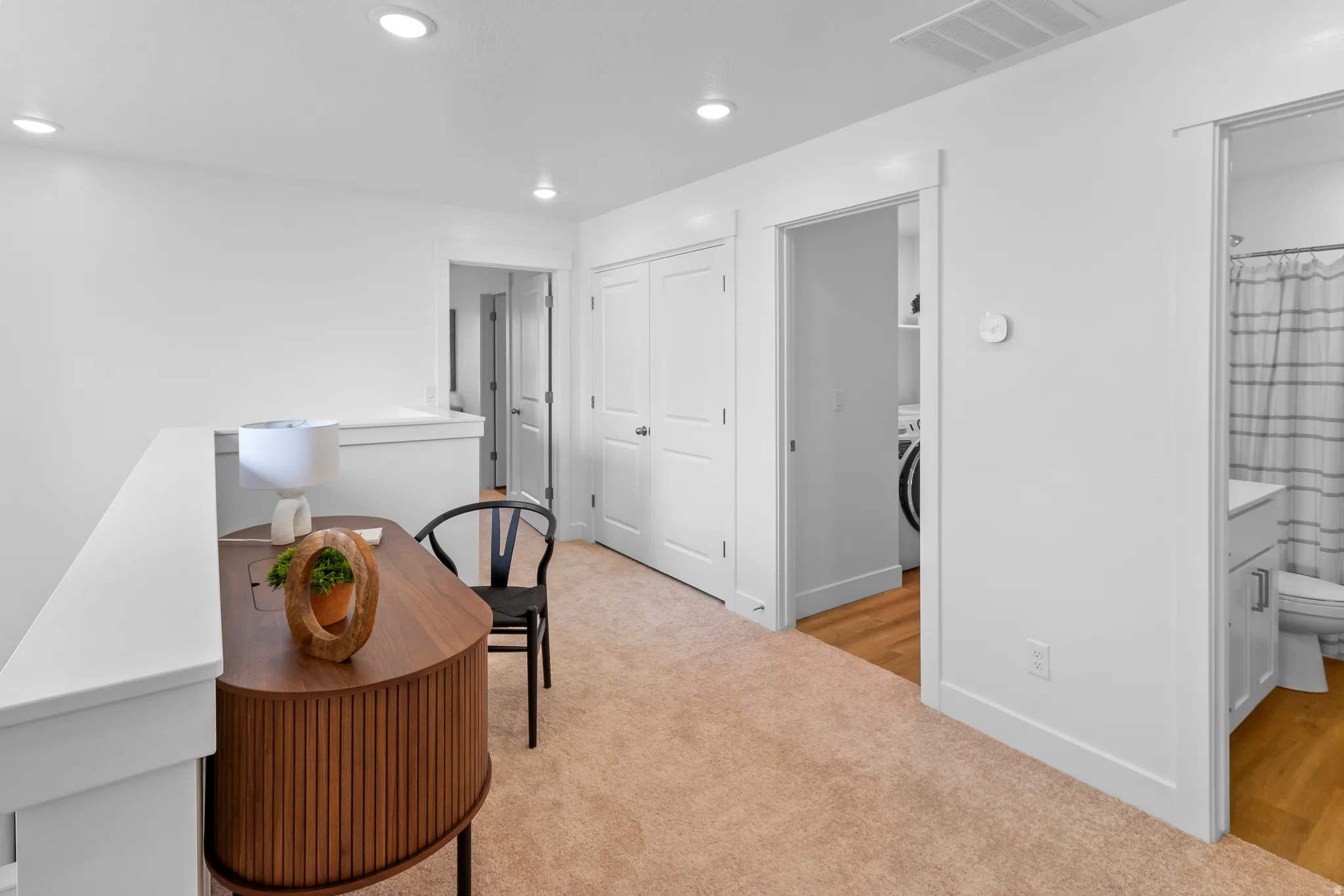 Recessed ceiling lighting, durable carpeting, interior doors, and a built-in laundry area with wood-finish flooring