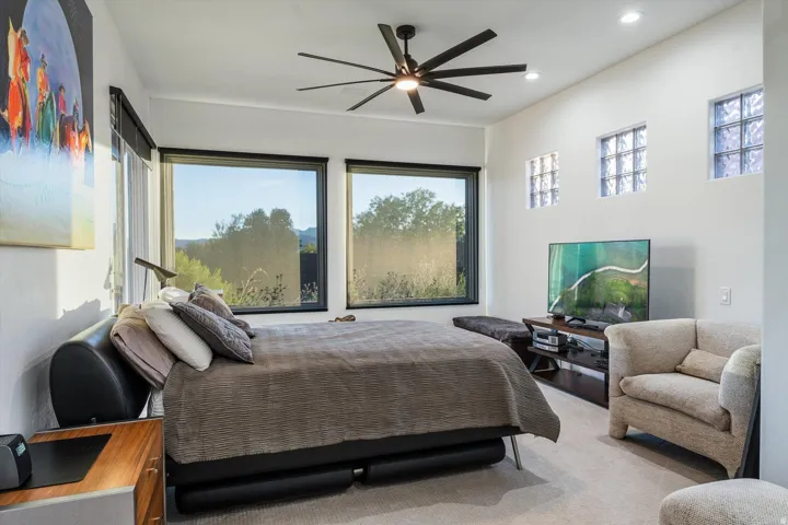 Expansive windows, ceiling fan, recessed lighting, glass block windows, and a built-in media console