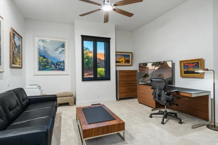 Recessed lighting, wood-finish ceiling fan, and a single window with black trim
