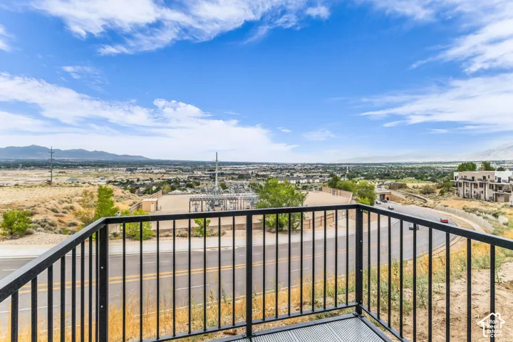 Elevated deck with black metal railing offering expansive panoramic vistas across the valley and distant mountain range