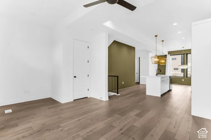 Open-concept living space with wood-finish flooring, recessed lighting, and a contemporary ceiling fan