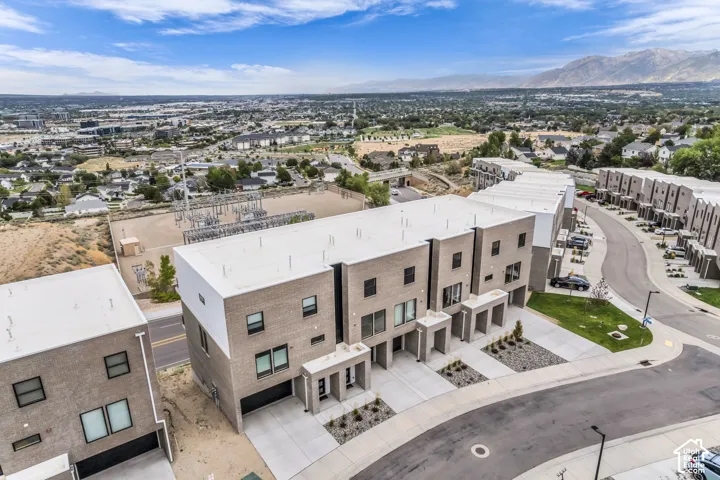 Modern residential complex featuring contemporary architecture with clean-lined facades, mixed material finishes including stone and stucco cladding, and multiple individual unit entries