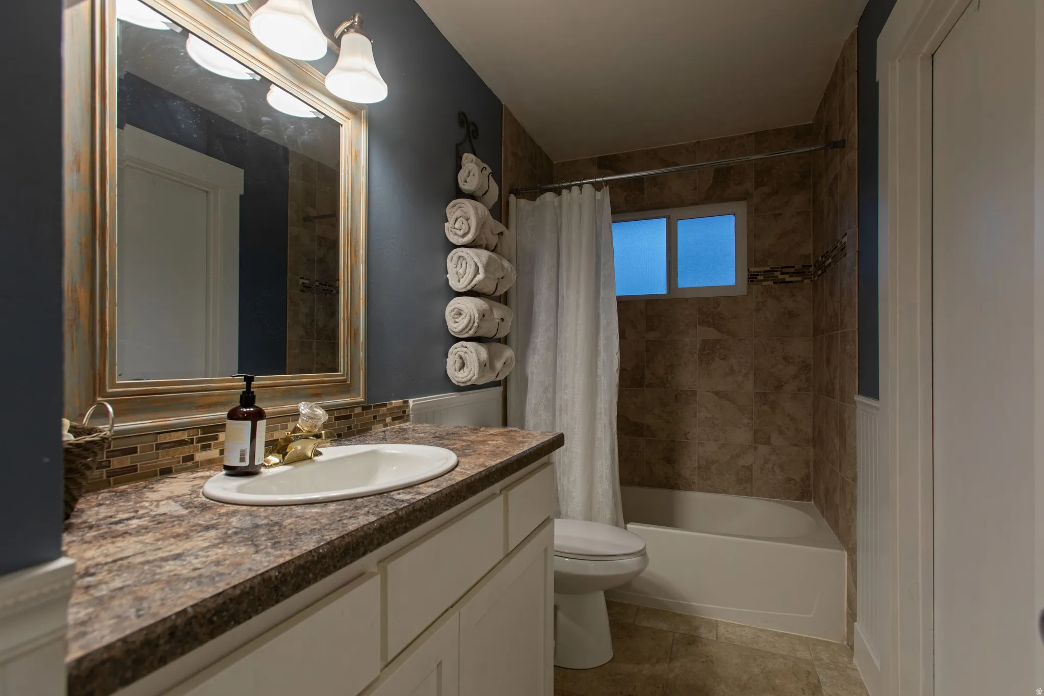 Vanity with integrated sink, patterned countertop, and mosaic tile backsplash