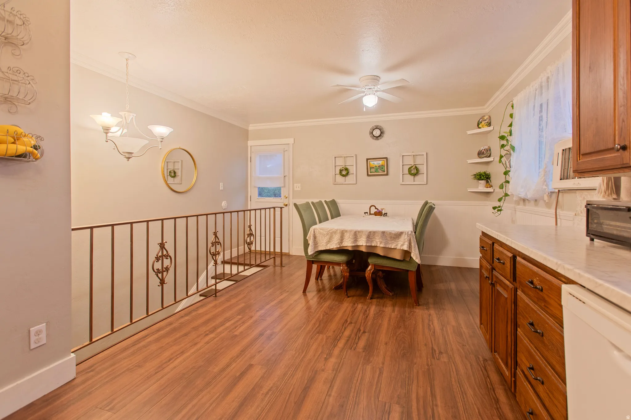 Wood-finish flooring throughout, featuring a detailed metal railing and crown molding