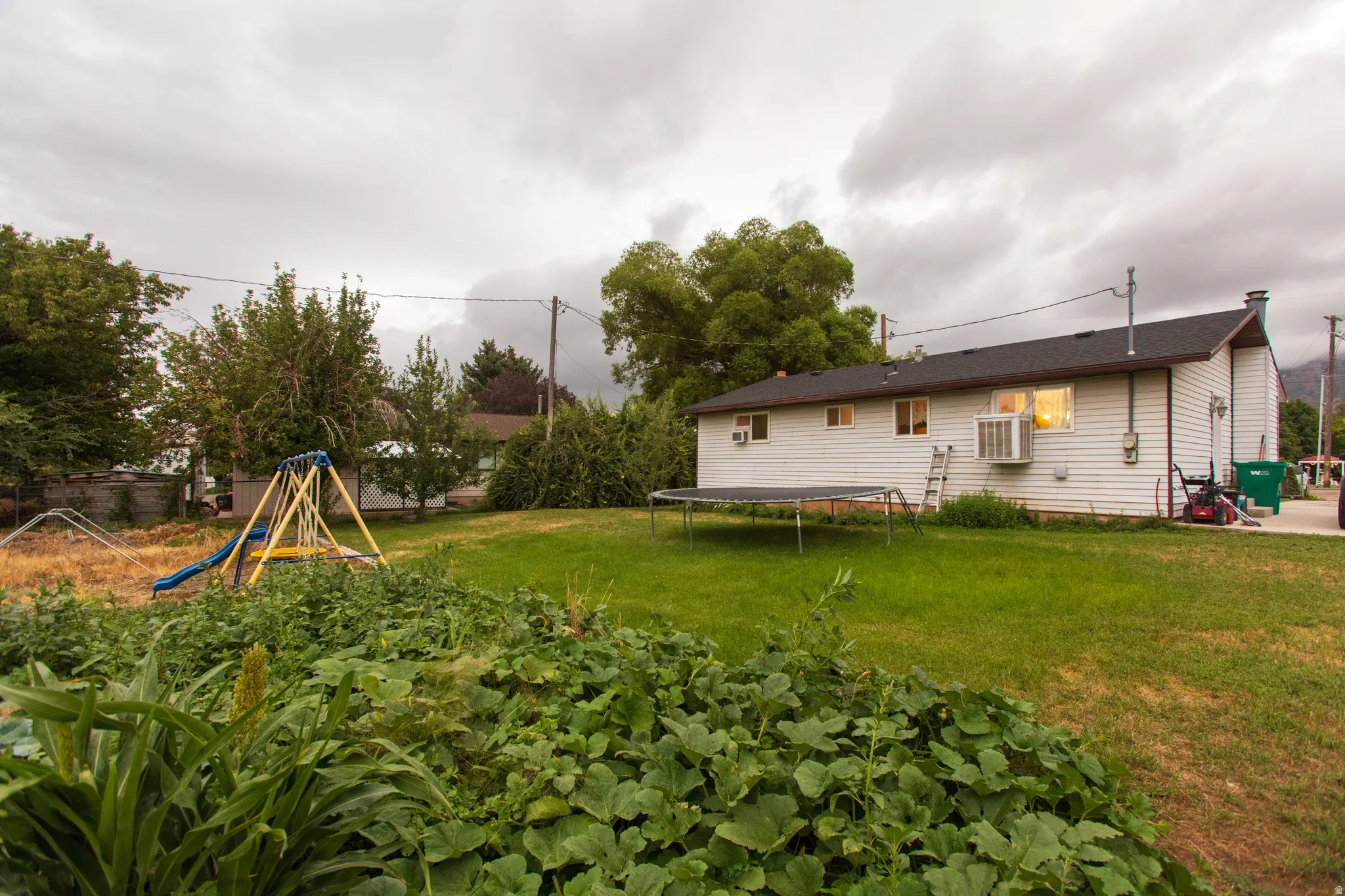 Expansive rear yard with a green lawn area and established landscaping