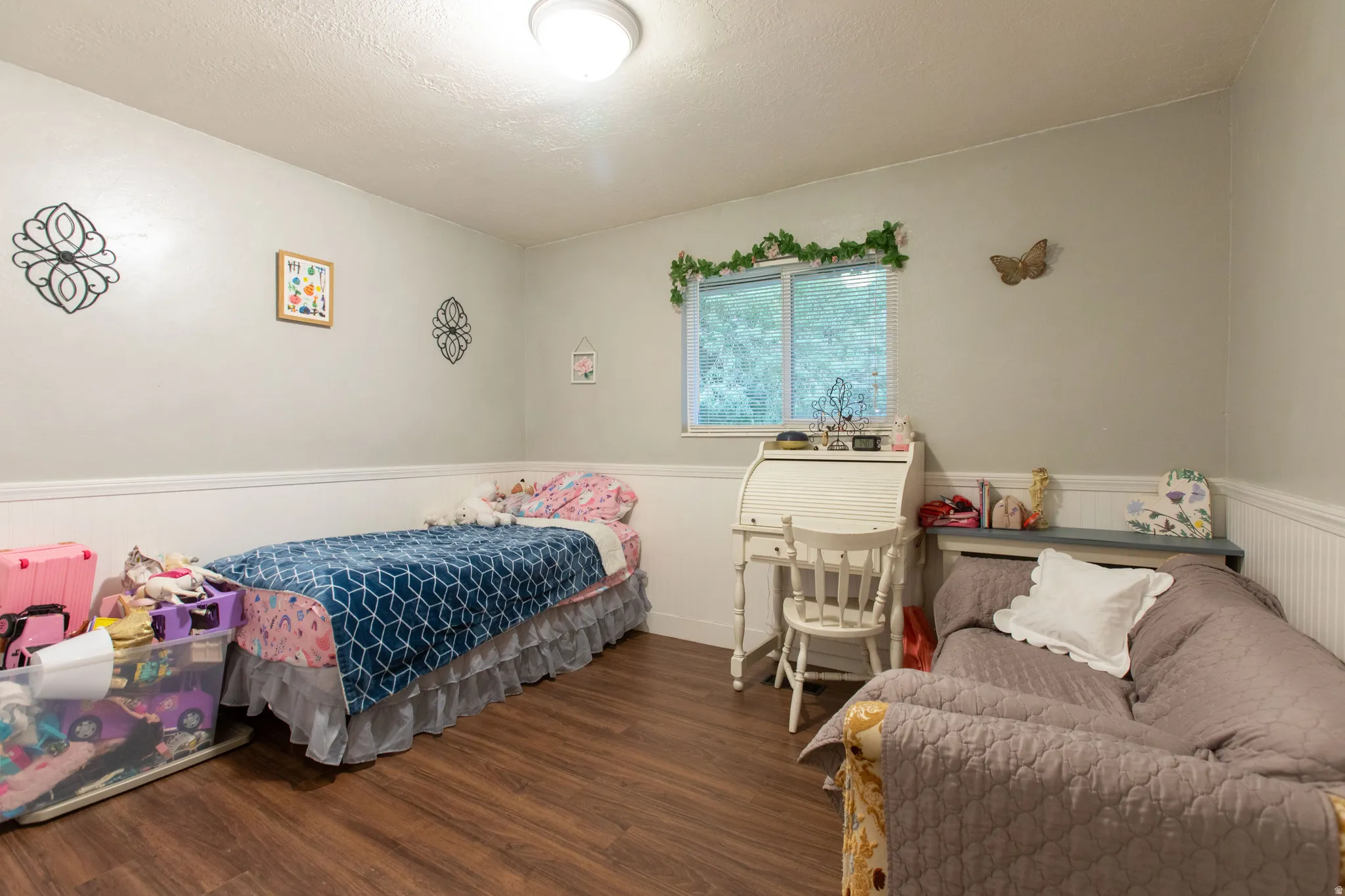Wood-finish flooring, white beadboard wainscoting, white walls, and a prominent window