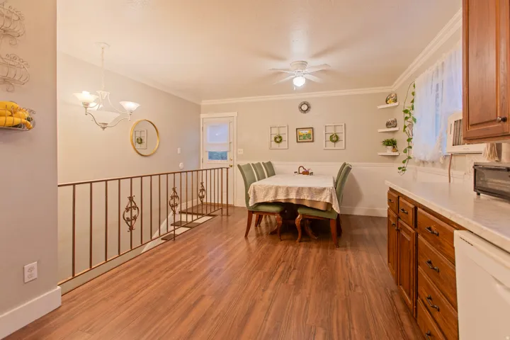 Wood-finish flooring throughout, featuring a detailed metal railing and crown molding