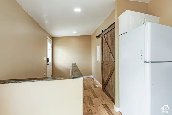 Wood-finish flooring, recessed lighting, and a wood barn door