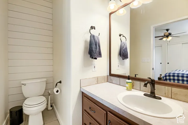 Vanity with an integrated sink and bronze-finish faucet, framed mirror, and horizontal plank wall accent