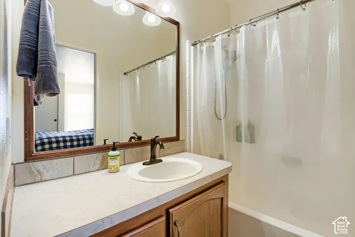 Built-in vanity with a countertop, integrated sink, and wood-finish cabinetry