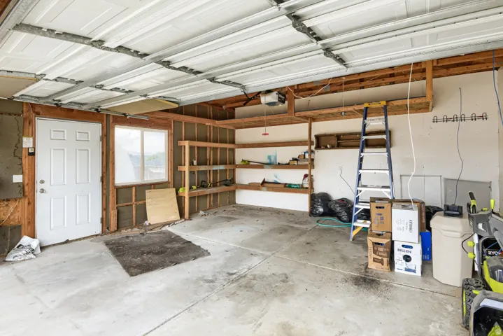 Concrete flooring, exposed framing, and built-in shelving offer functional storage