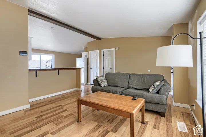 Wood-finish flooring throughout, light neutral paint, white trim, and a built-in breakfast bar with iron brackets