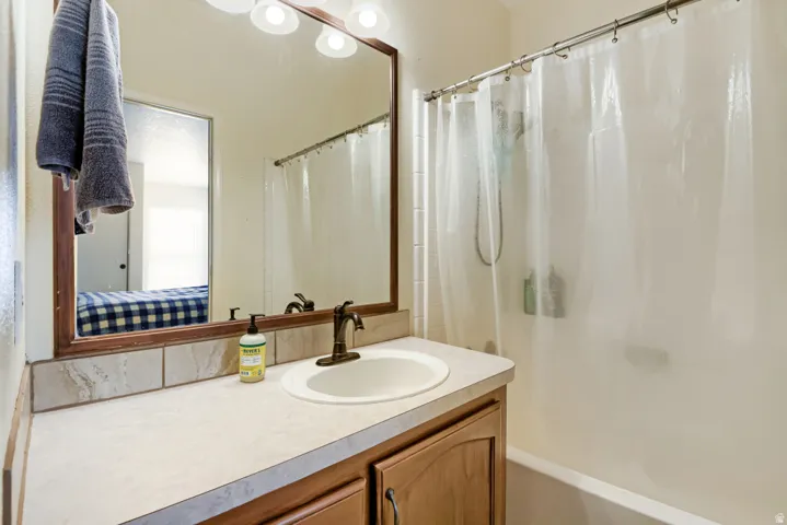 Built-in vanity with a countertop, integrated sink, and wood-finish cabinetry