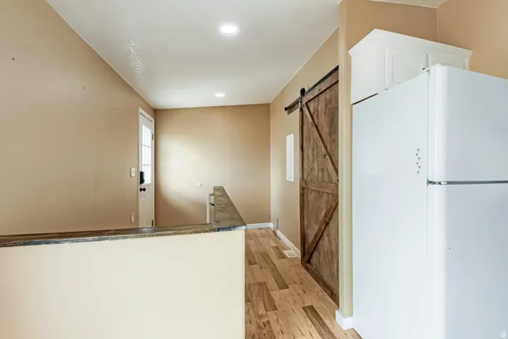 Wood-finish flooring, recessed lighting, and a wood barn door