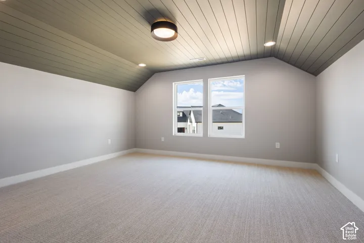 Vaulted ceiling with wood-finish paneling, recessed lighting, and a flush mount fixture