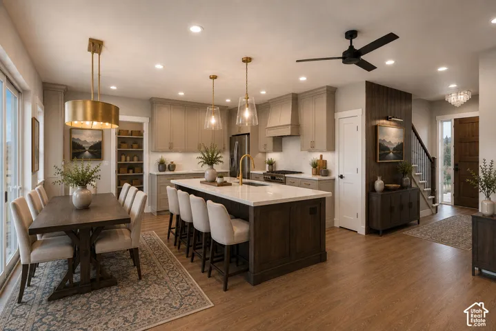 Spacious kitchen featuring an expansive island with seating, pendant lighting, and light-toned cabinetry