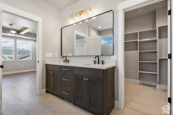 Dual vanity with dark wood-finish cabinetry, white countertops, and matte black fixtures