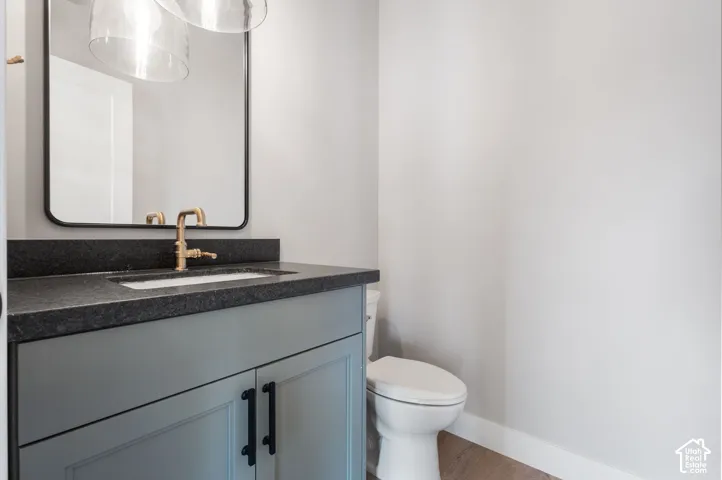 Vanity with a dark countertop, integrated sink, and bronze-finish faucet