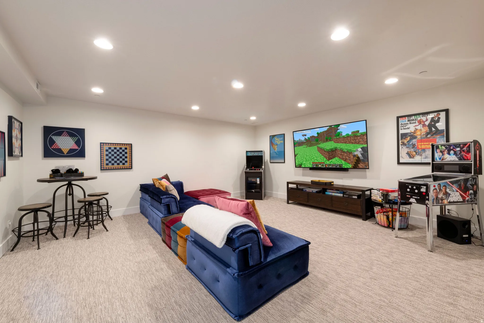 Recessed lighting, light-toned carpeting, white walls, and a built-in media console