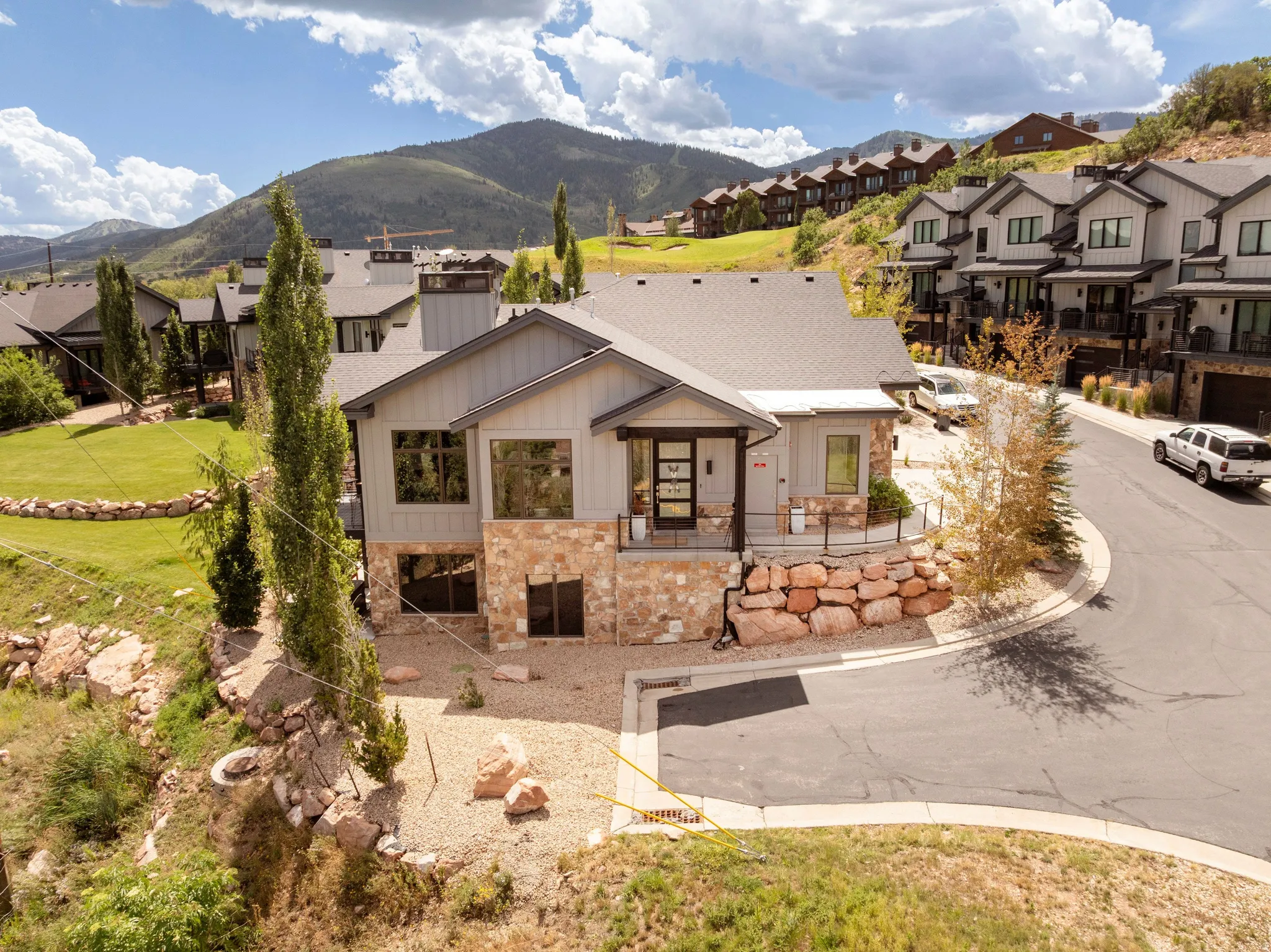Contemporary architecture featuring a multi-tone facade, stone accents, and a dark shingle roof