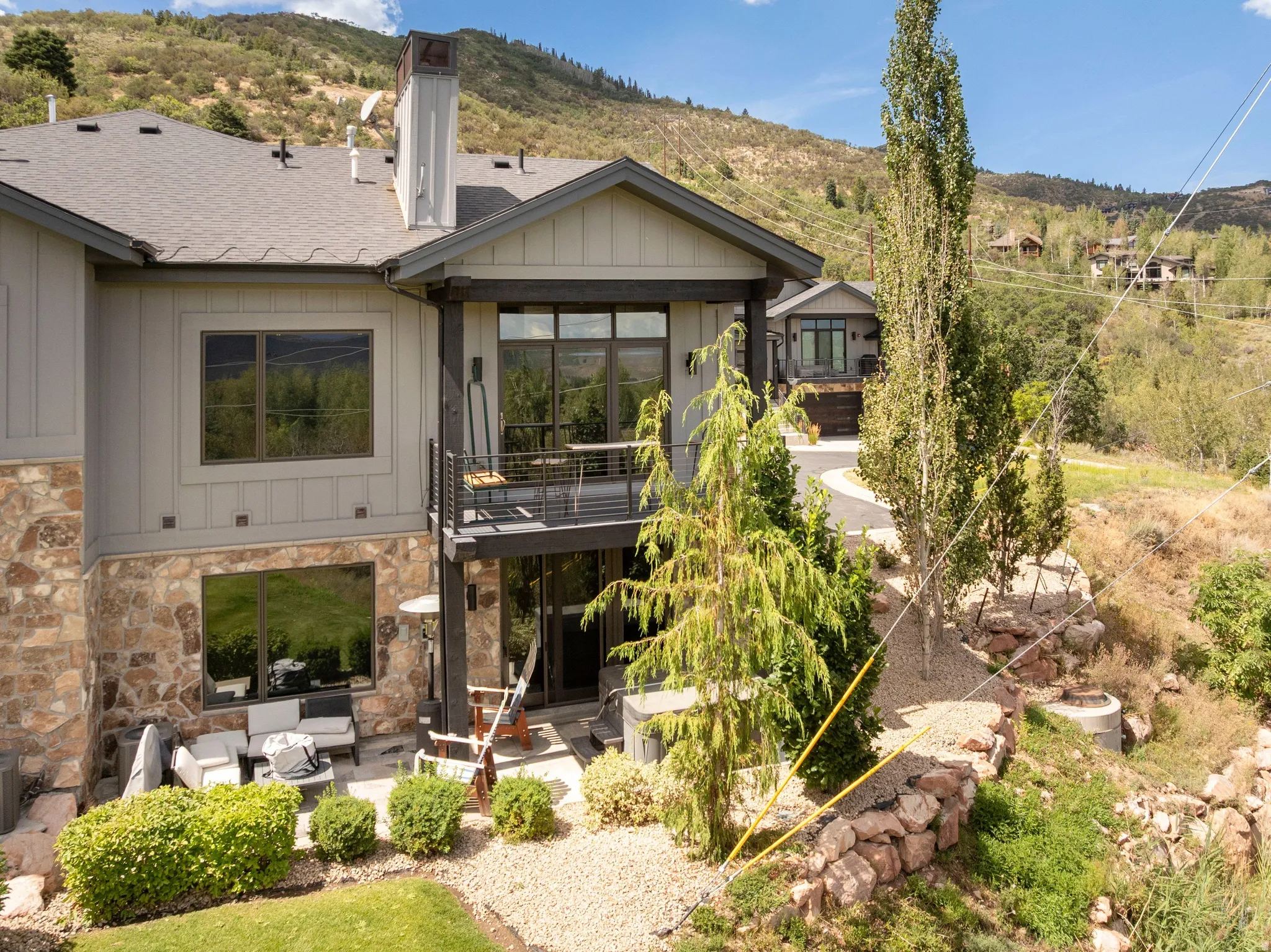 Multi-level exterior with board and batten siding, stone facade, and a shingled roof