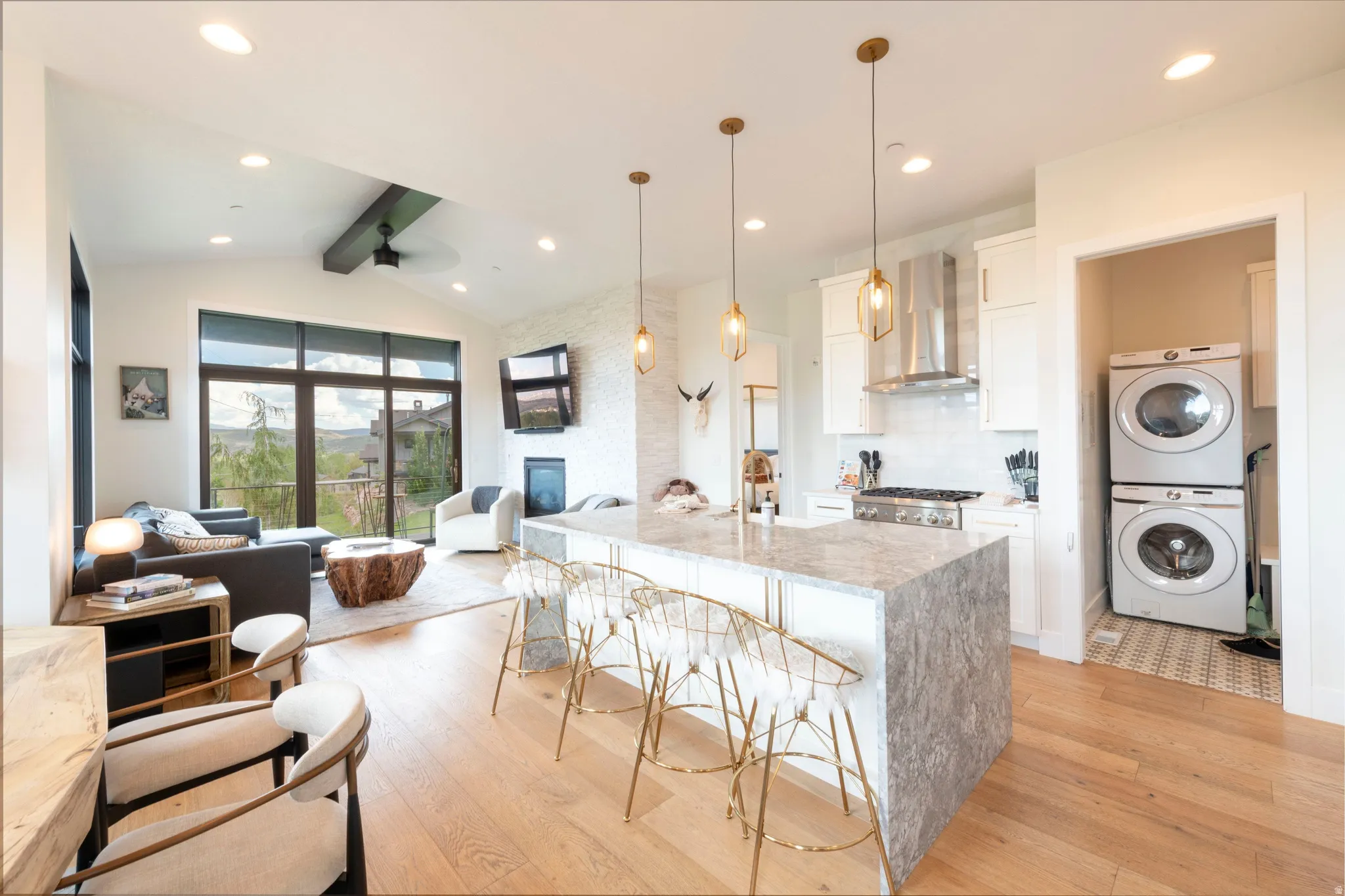 Open-concept living area with wood-finish flooring, vaulted ceilings, and recessed lighting