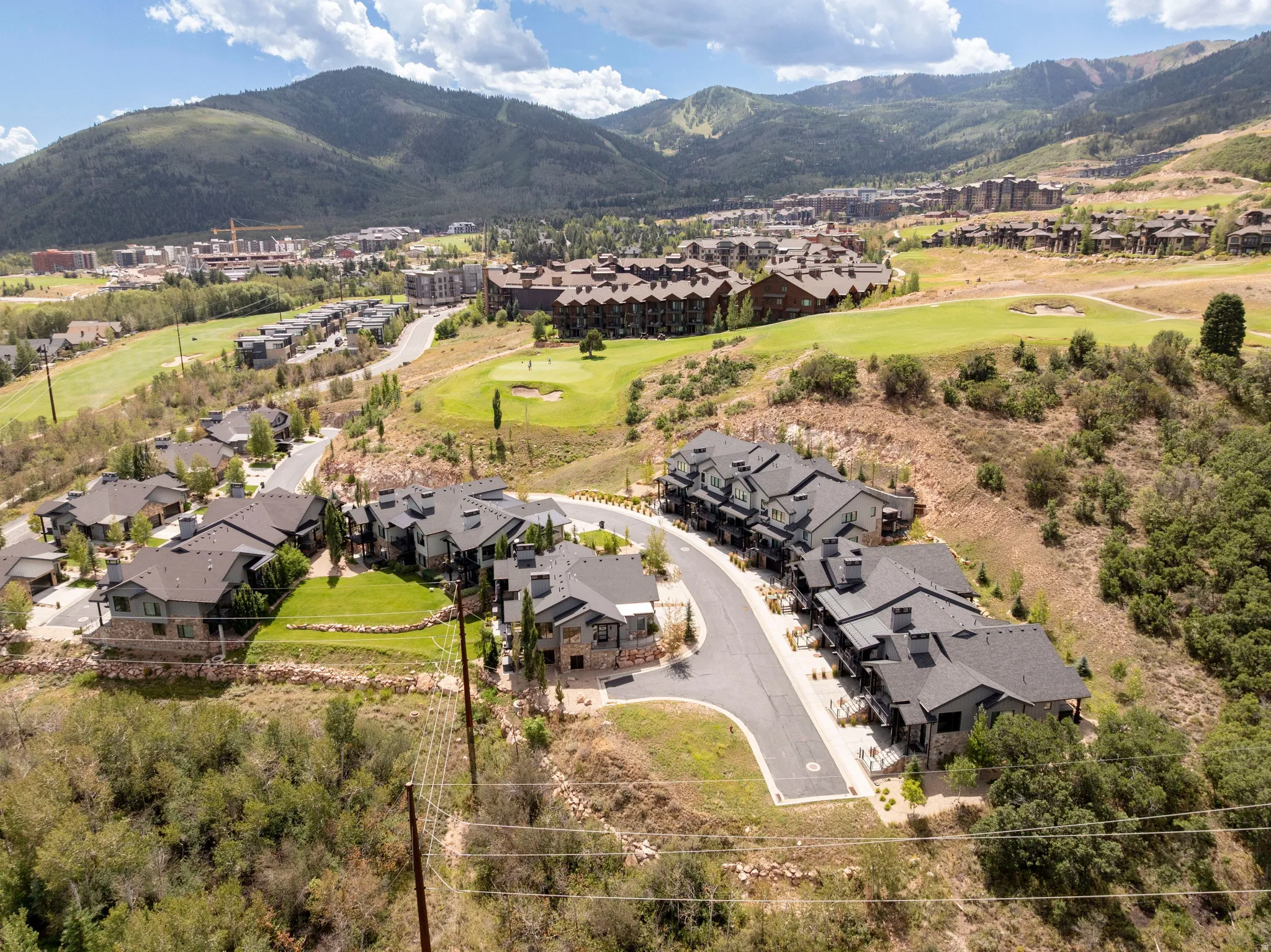 Mountainous landscape with multiple properties, a golf course, and paved roadways