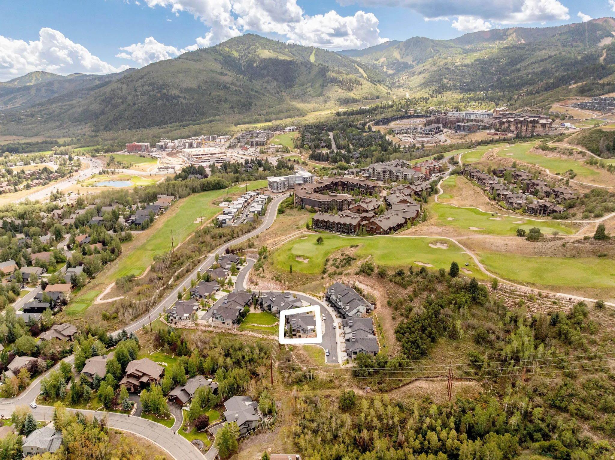 Expansive mountain landscape with diverse residential architecture and golf course elements