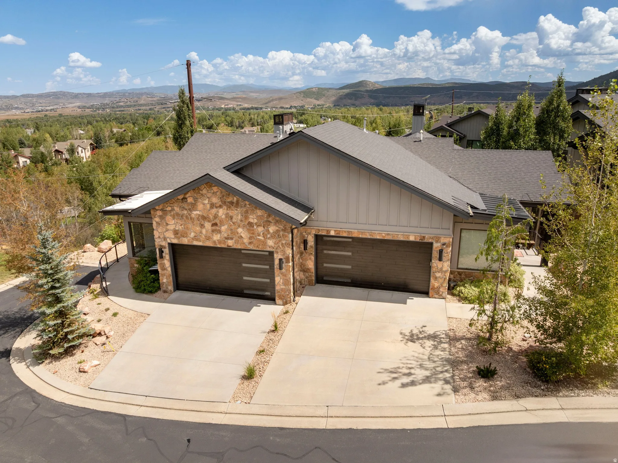Stone veneer and siding exterior with dark trim accents