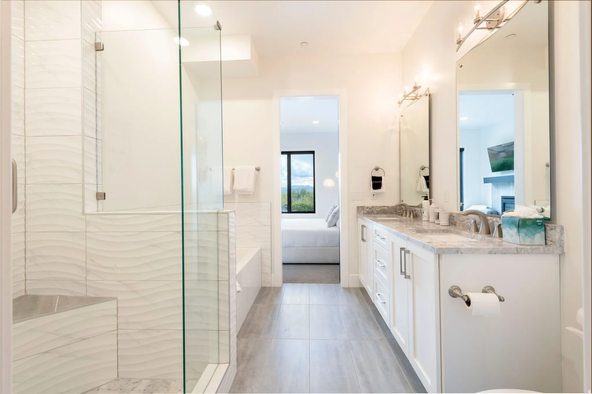 Glass-enclosed shower with a built-in bench and textured tile