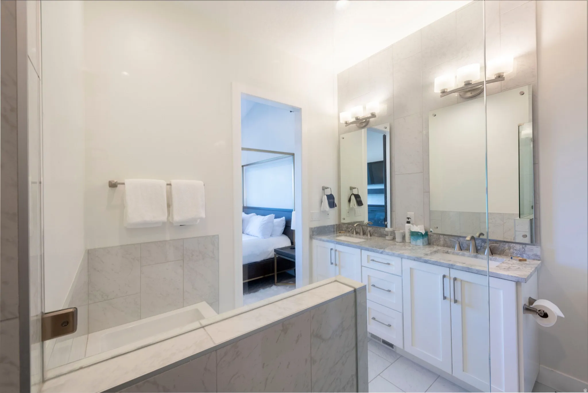 Dual vanity with white cabinetry, under-mount sinks, and light-toned countertops