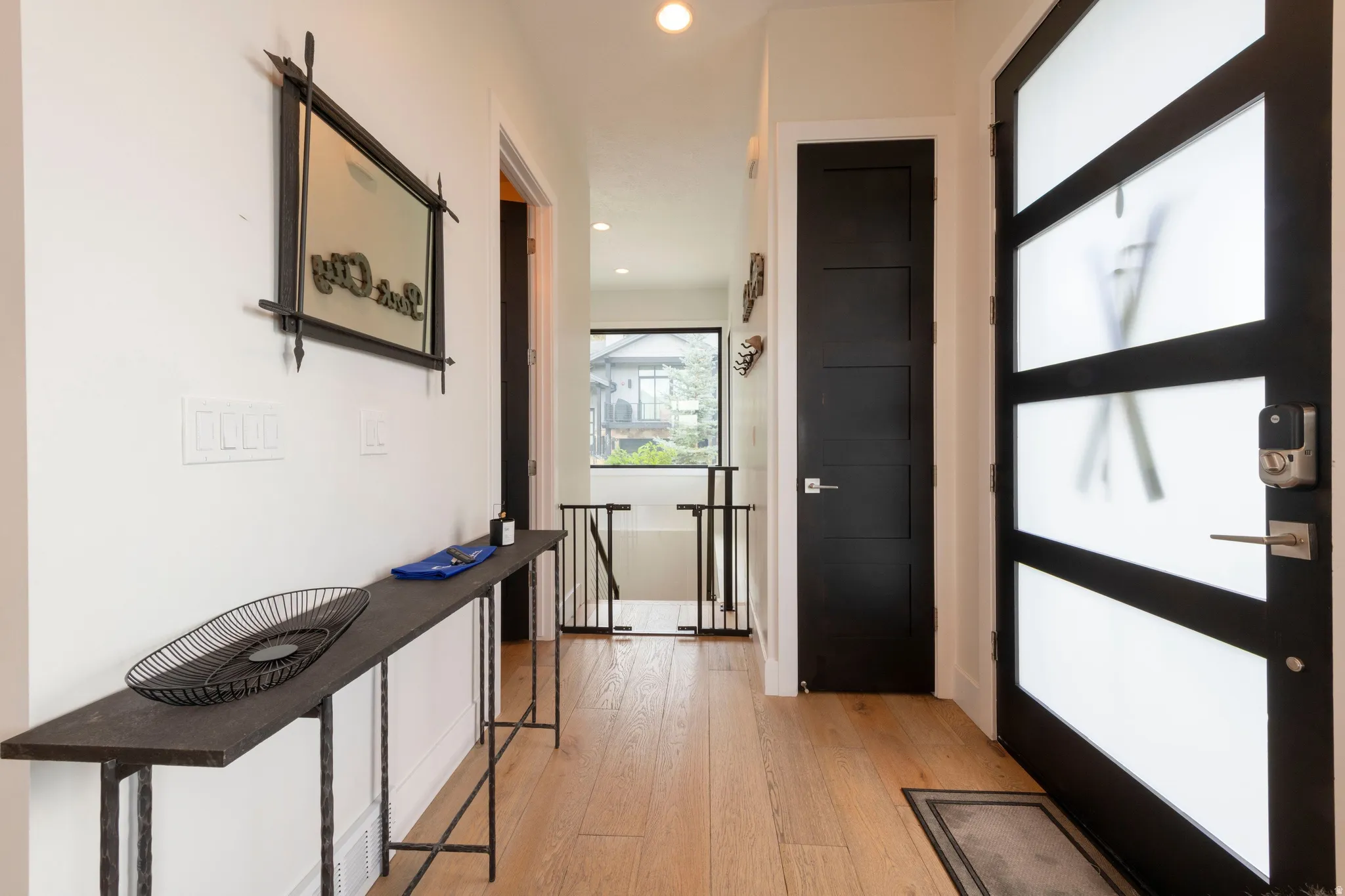 Light wood-finish flooring, modern entry door with frosted panels, contemporary interior door, and recessed lighting