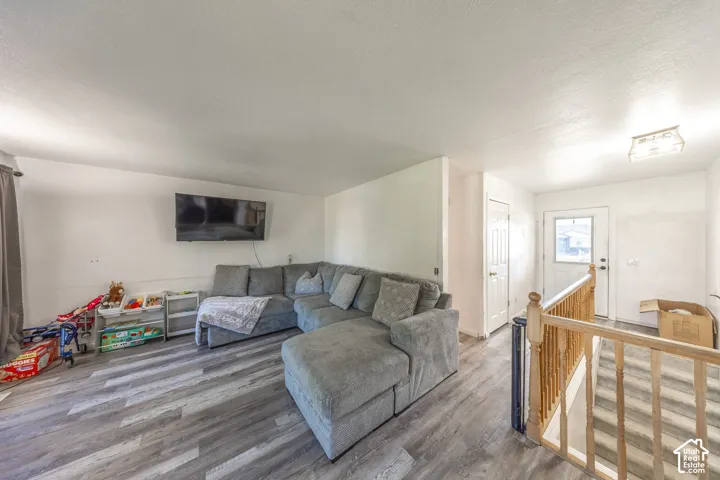 Wood-finish flooring, white walls, and a front entry door with a privacy window