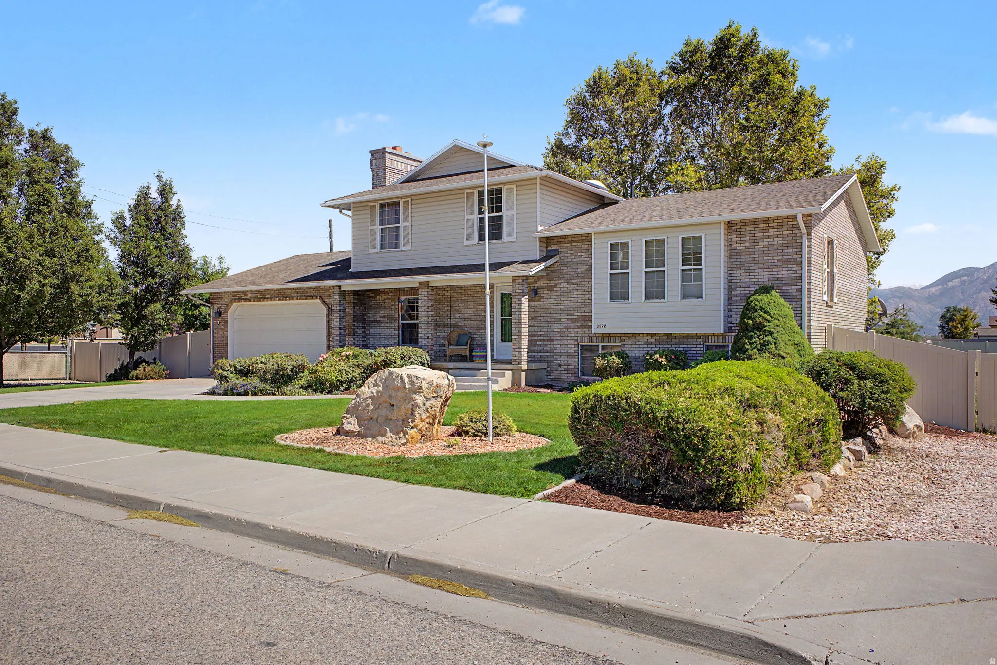 Two-story home with a brick and siding exterior, an attached garage, and a covered porch