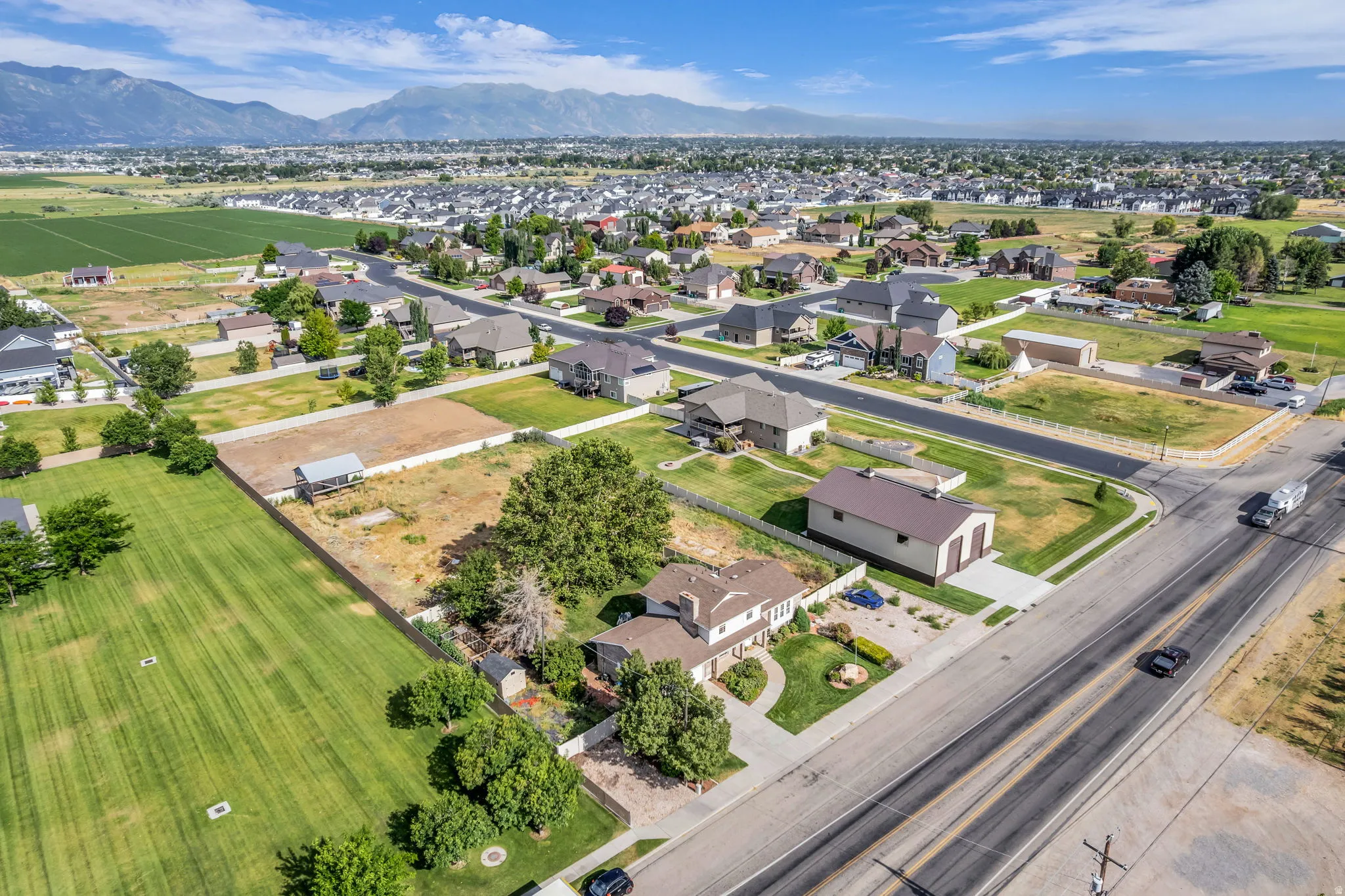 Expansive lot featuring mature trees, a detached outbuilding, and direct road frontage
