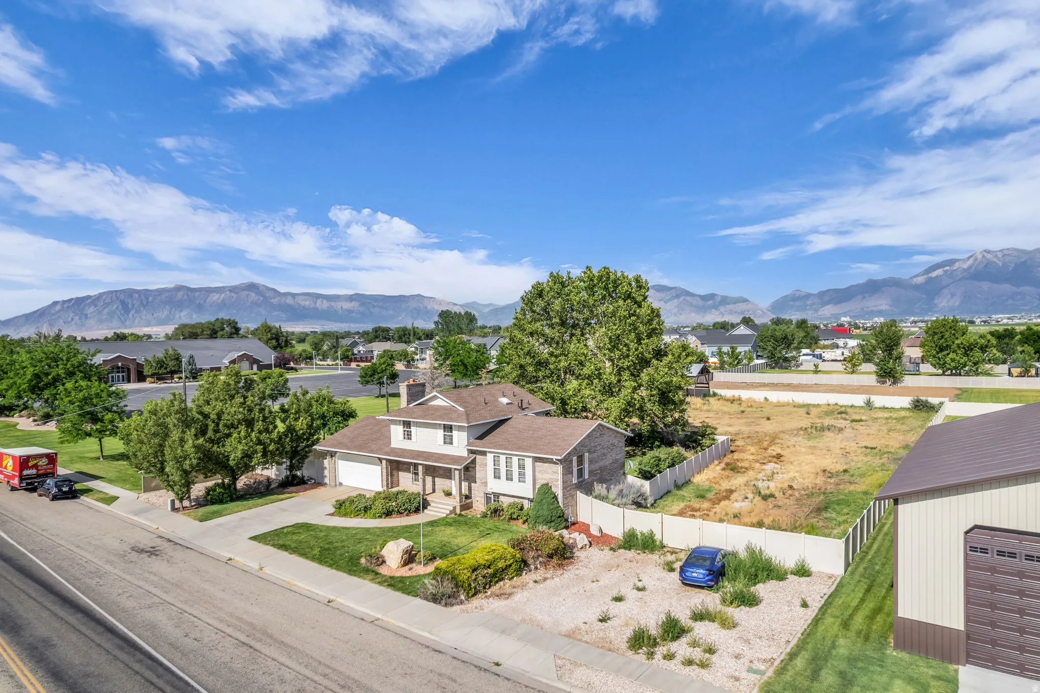 Two-story residence with a two-car garage, front yard landscaping, and mountain backdrop