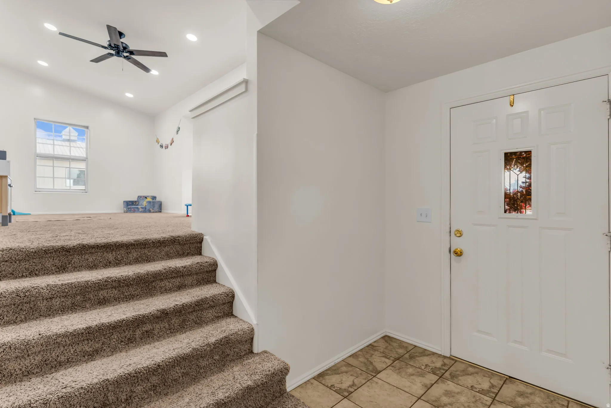 Tiled entry with paneled door and decorative glass insert