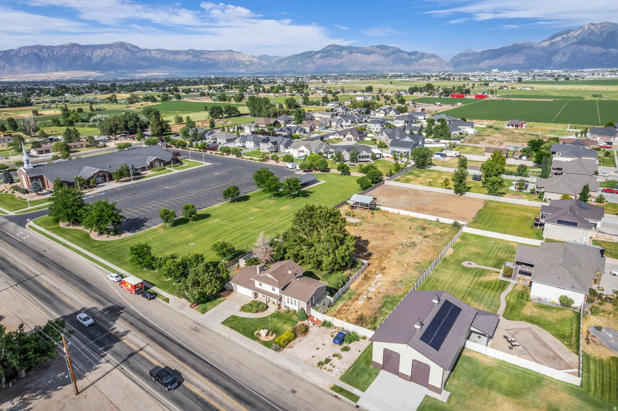 Expansive land parcel with mountain backdrop, surrounded by residential properties and green spaces