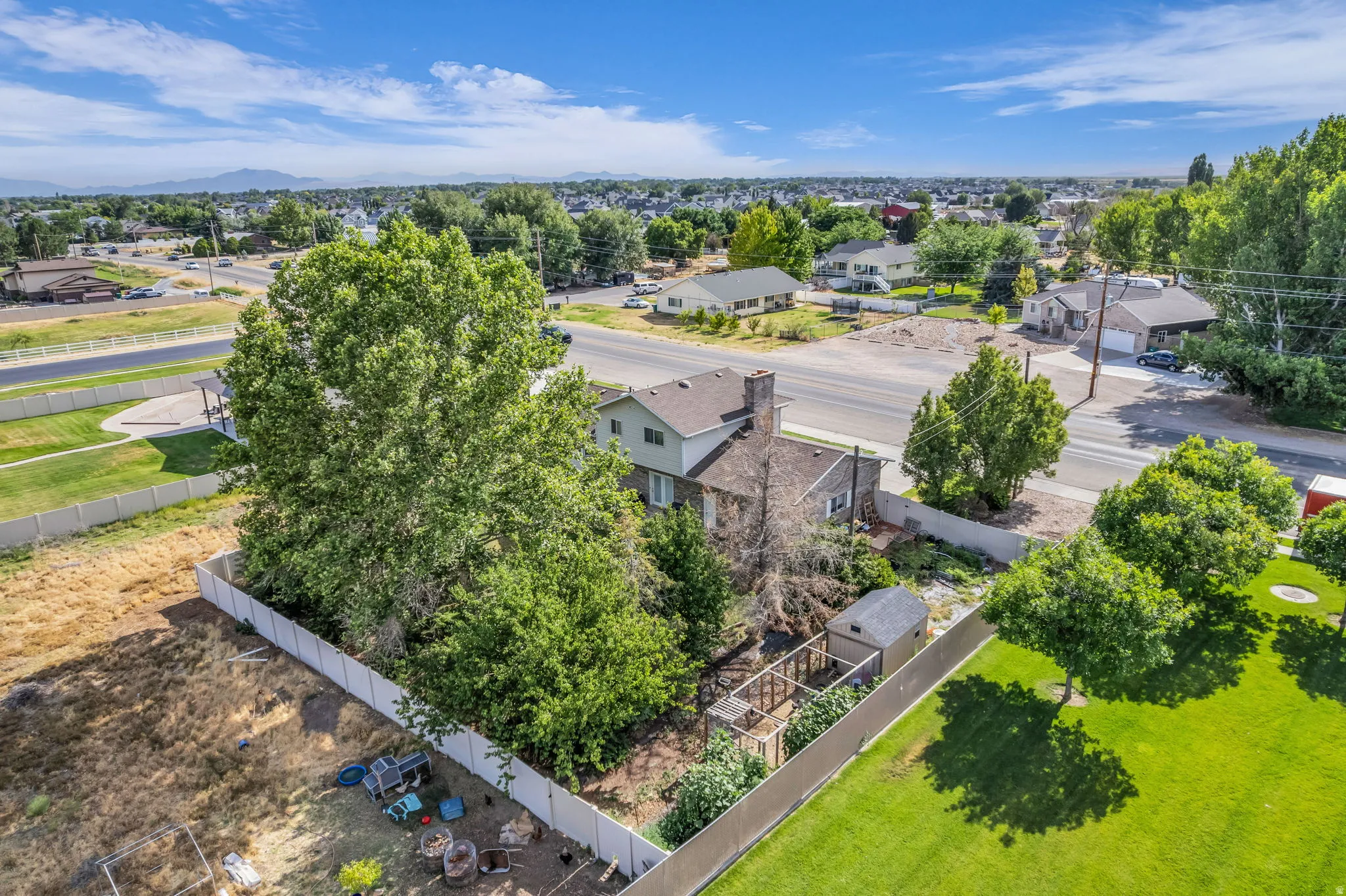 Expansive lot with mature trees, fenced perimeter, and a detached shed