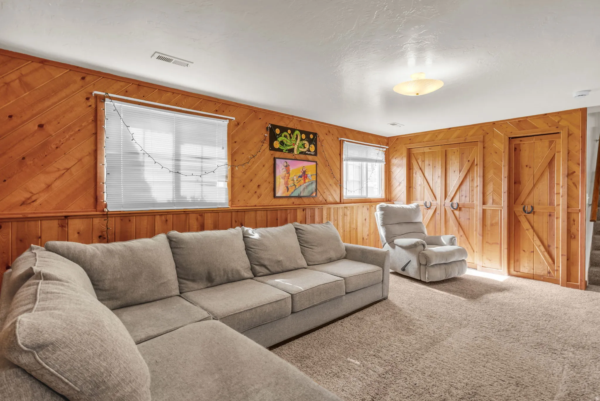 Wood-paneled walls with wainscoting, recessed window, and barn-style doors