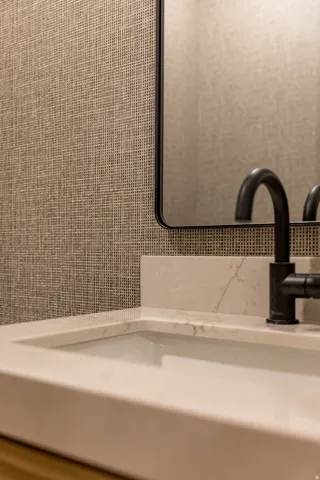 Modern bathroom vanity featuring a rectangular vessel sink, light-toned countertop, and matte black wall-mounted faucet